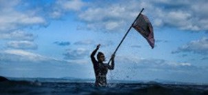 person holding a flag in sea waves